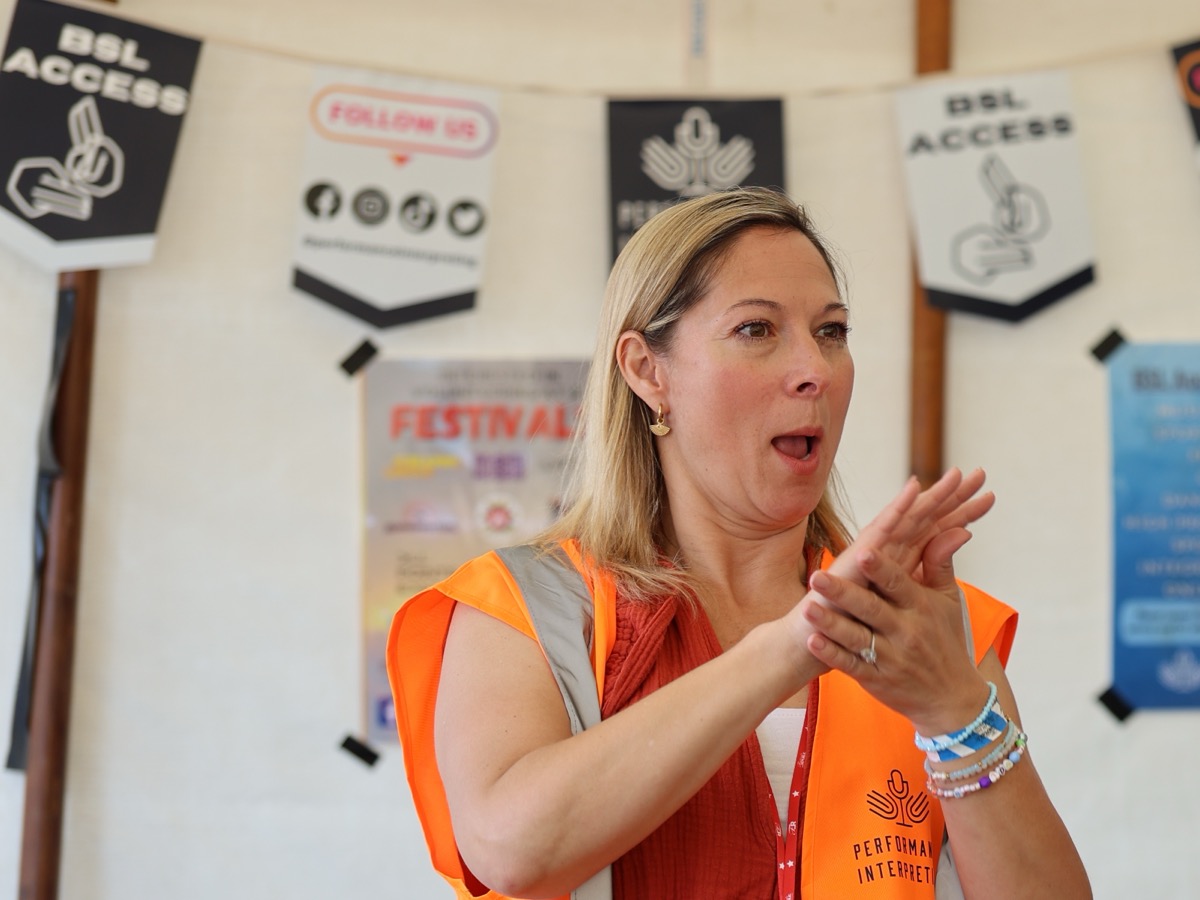 Marie Pascall signing BSL at a Performance Interpreting festival access point
